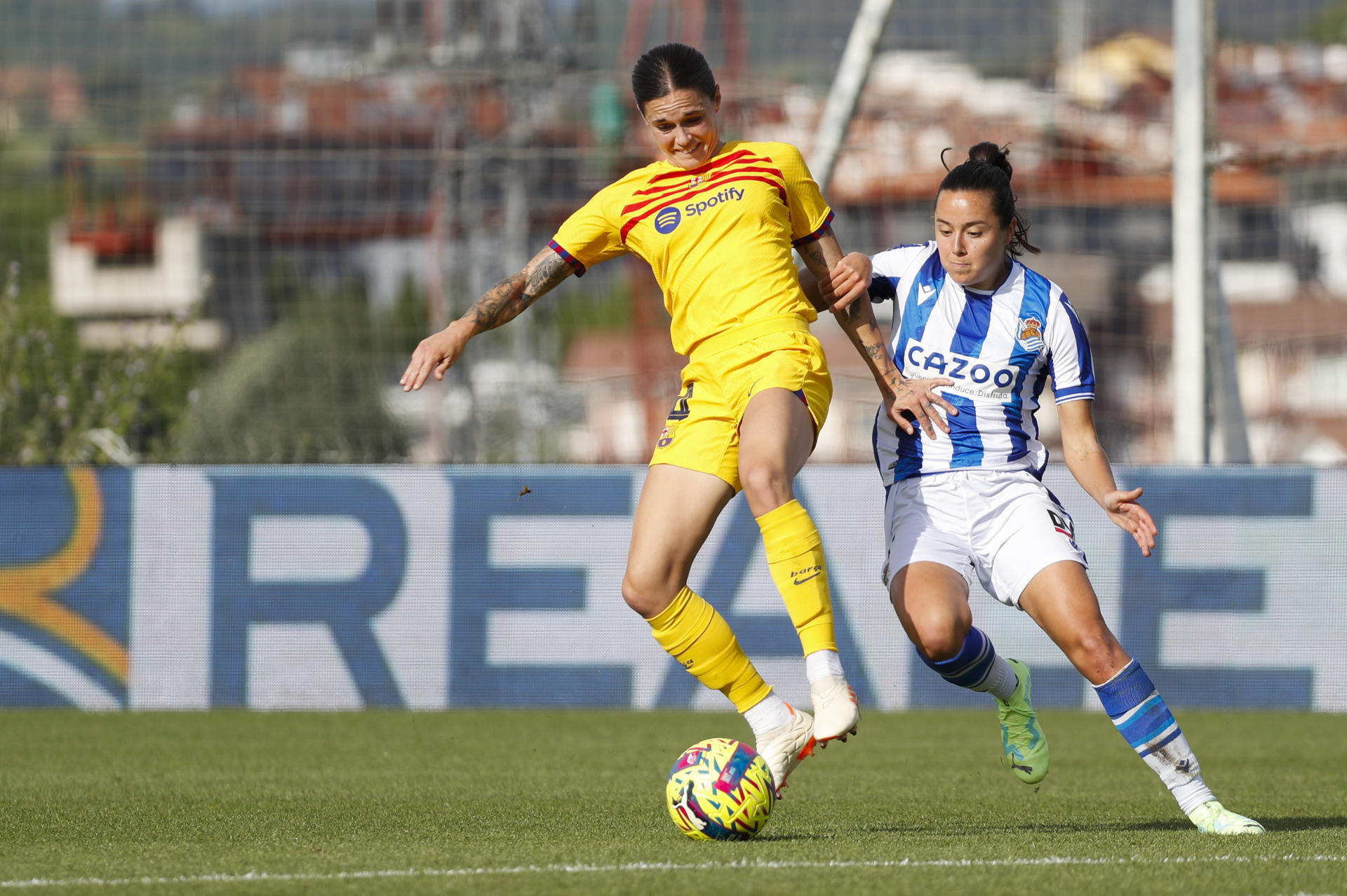 La defensa del FC Barcelona María León (i) trata de jugar un balón ante Amaiur Sarriegi, de la Real Sociedad, durante el partido de la Liga F de fútbol disputado este sábado en San Sebastián. EFE/Juan Herrero
