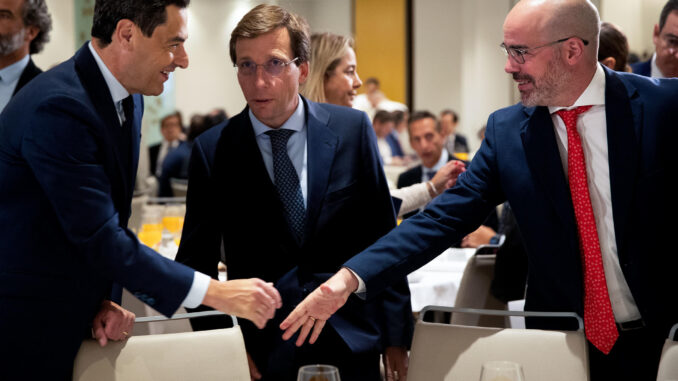 El presidente del PP de Andalucía y presidente de la Junta, Juanma Moreno (i), saluda al delegado del Gobierno en la Comunidad de Madrid, Francisco Martín Aguirre (d), en presencia del alcalde de Madrid y candidato del PP a la reelección, José Luis Martínez Almeida (c), durante un desayuno informativo celebrado este miércoles en Madrid. EFE/ J.P. Gandul
