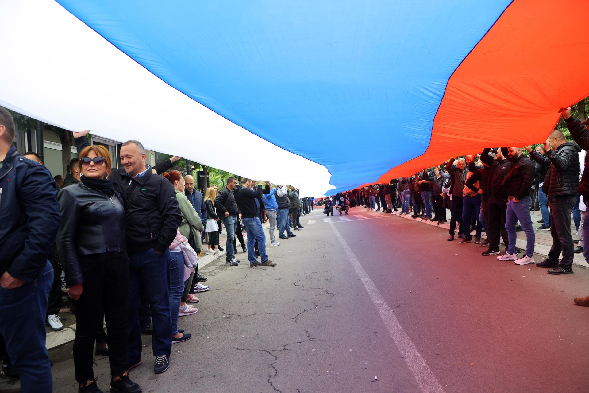 Manifestantes despliegan una bandera gigante serbia ante la alcaldía de Zvecan, en Kosovo. EFE/EPA/GEORGI LICOVSKI
