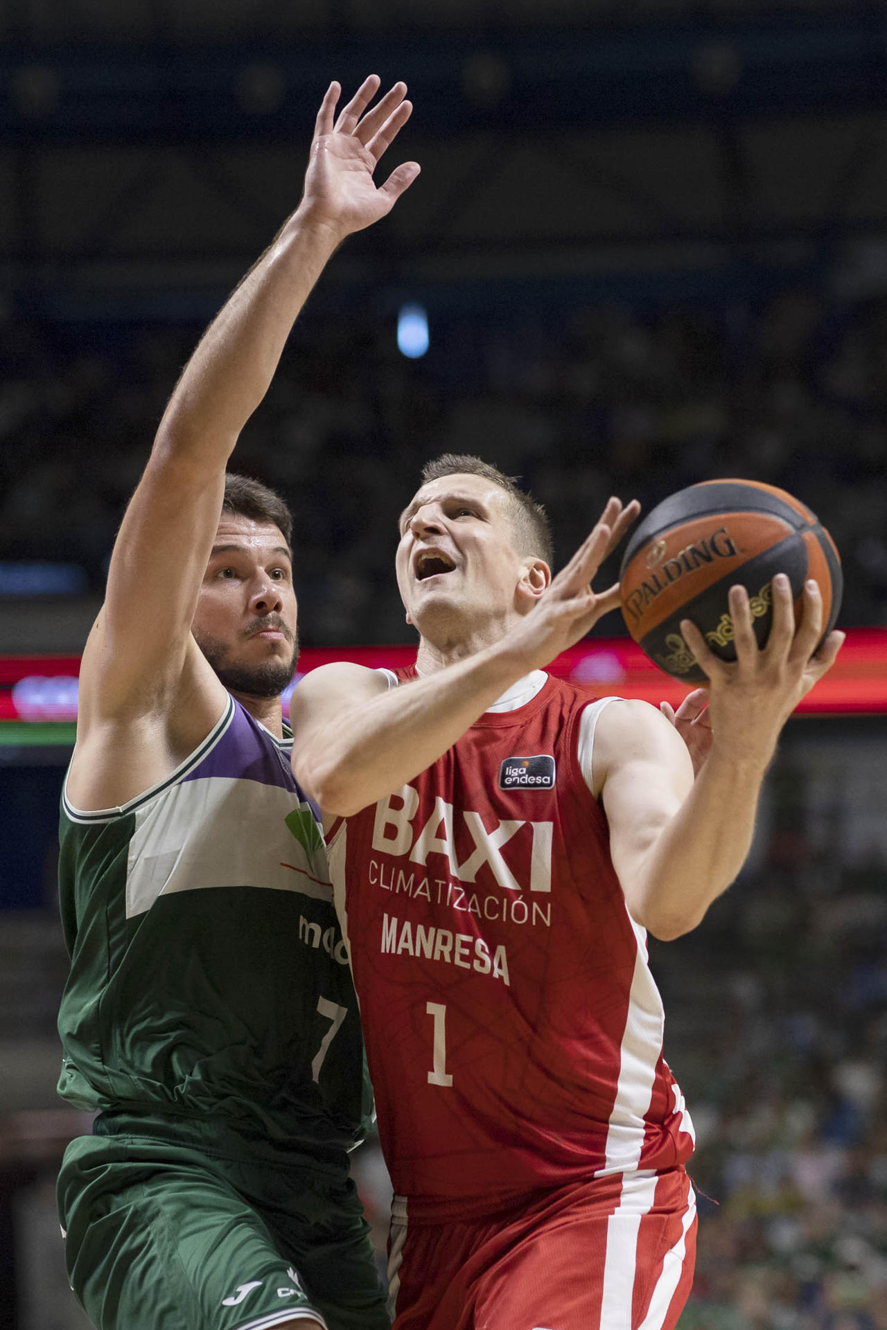 El alero polaco de Baxi Manresa, Adam Waczynski (d), con el balón ante la defensa del alero de Unicaja, Jonathan Barreiro, durante el encuentro correspondiente a la fase regular de la Liga Endesa disputado hoy miércoles en el Palacio de los Deportes José María Martín Carpena, en Málaga. EFE/Carlos Díaz.
