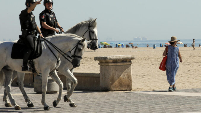 Dos policias a caballo patrullan por la playa de la Malvarrosa de Valencia en una imagen de archivo. EFE/ Juan Carlos Cárdenas
