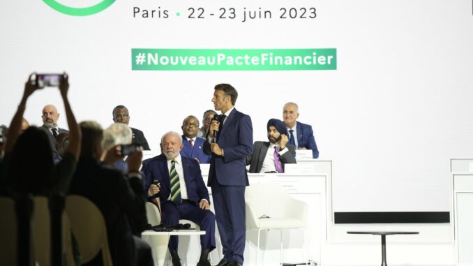 El presidente de Francia, Emmanuel Macron (de pie), en la sesión de clausura de la Cumbre del Nuevo Pacto Financiero Mundial, mientras escucha el presidente de Brasil, Luiz Inacio Lula Da Silva (C, sentado), en París. EFE/EPA/Lewis Joly / POOL MAXPPP OUT
