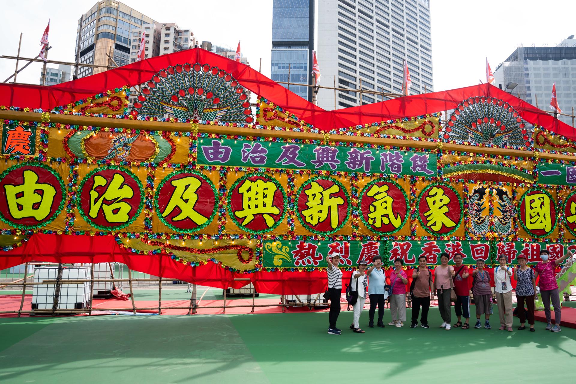 Varias personas posan en Hong Kong ante un mural de flores con motivo de las celebraciones por el 26º aniversario del regreso a la soberanía china de la excolonia británica. EFE/EPA/BERTHA WANG
