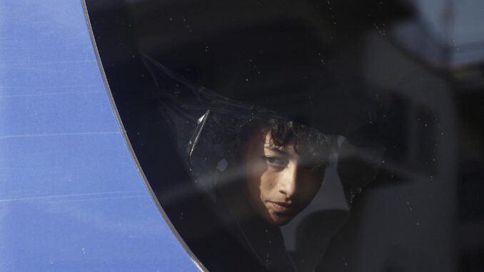 Un migrante rescatado del naufragio frente a las costas de Grecia se asoma a la ventanilla del autobus en el que es traladado a un centro de acogida. (Grecia) EFE/EPA/YANNIS KOLESIDIS
