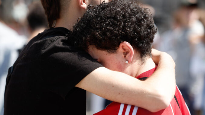 Abrazos emocionados entre compañeros tras el minuto silencio por la muerte de cuatro jóvenes de Moralzarzal (Madrid) en un accidente de tráfico cuando regresaban de las fiestas del municipio vecino de Colllado Villalba. EFE/ Sergio Perez
