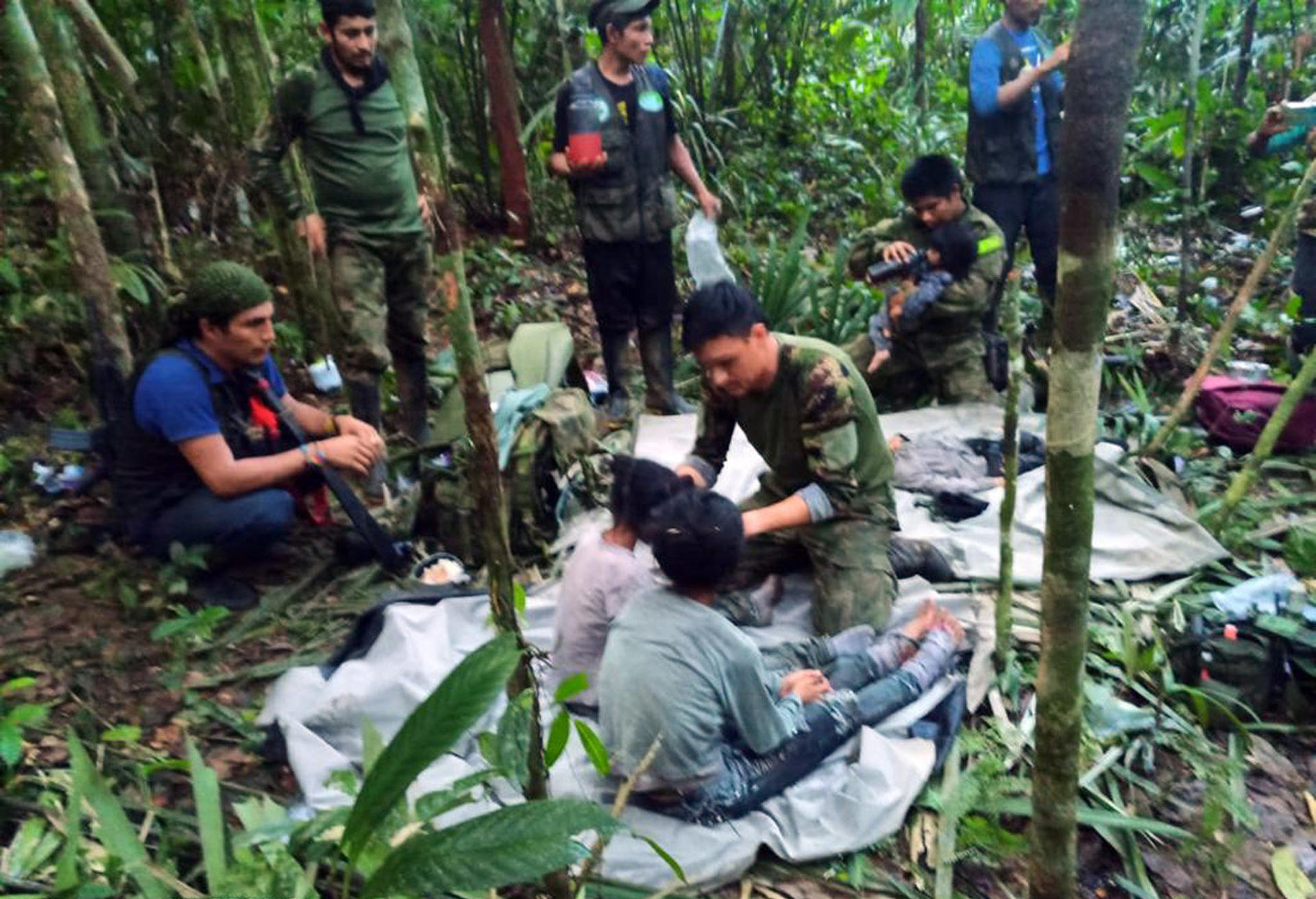 Fotografía cedida hoy por las Fuerzas Militares de Colombia que muestra a soldados e indígenas mientras atienden a los niños rescatados tras 40 días en la selva, en Guaviare (Colombia). EFE/Fuerzas Militares de Colombia
