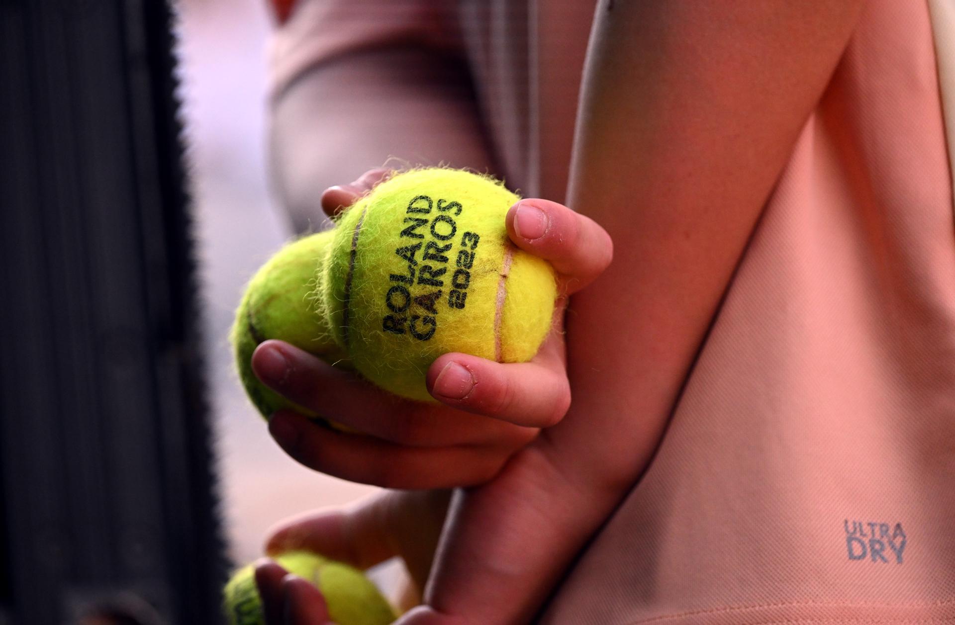 Un recogepelotas espera su turno mientras Iga Swiatek de Polonia juega contra Beatriz Haddad Maia de Brasil en su partido de semifinales femenino durante el torneo de tenis Grand Slam del Abierto de Francia en Roland Garros en París. Francia. EFE/EPA/CAROLINE BLUMBERG
