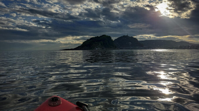 Un hombre practica paddle surf este viernes en la bahía de La Concha de San Sebastián. EFE/Javier Etxezarreta
