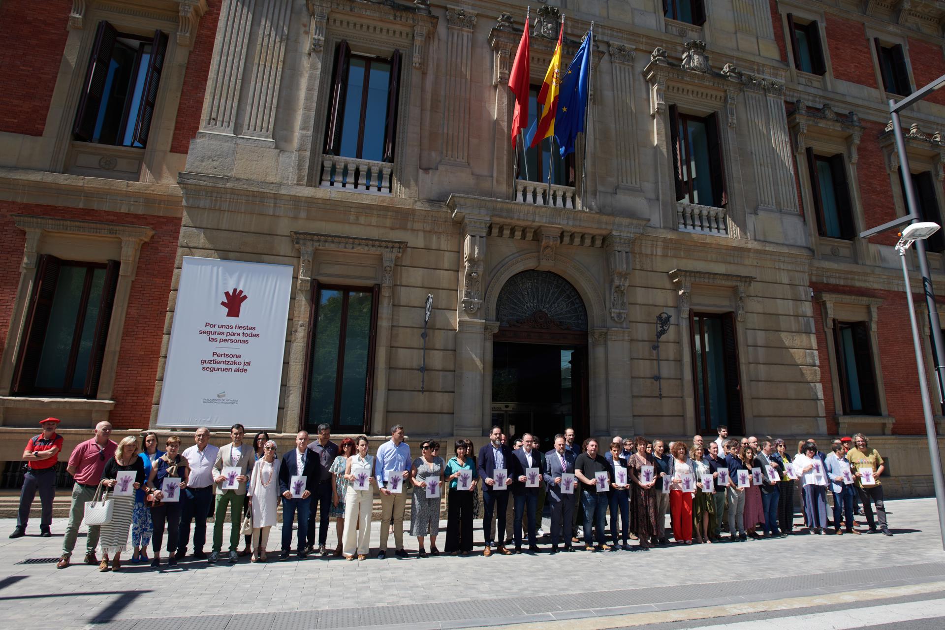 Parlamentarios forales, junto con representantes del Gobierno de Navarra, y del Ayuntamiento de Pamplona, durante una concentración este lunes a las puertas del Legislativo navarro en señal de repulsa por el asesinato por violencia machista cometido el sábado, día 1, en la capital navarra. EFE/Iñaki Porto.
