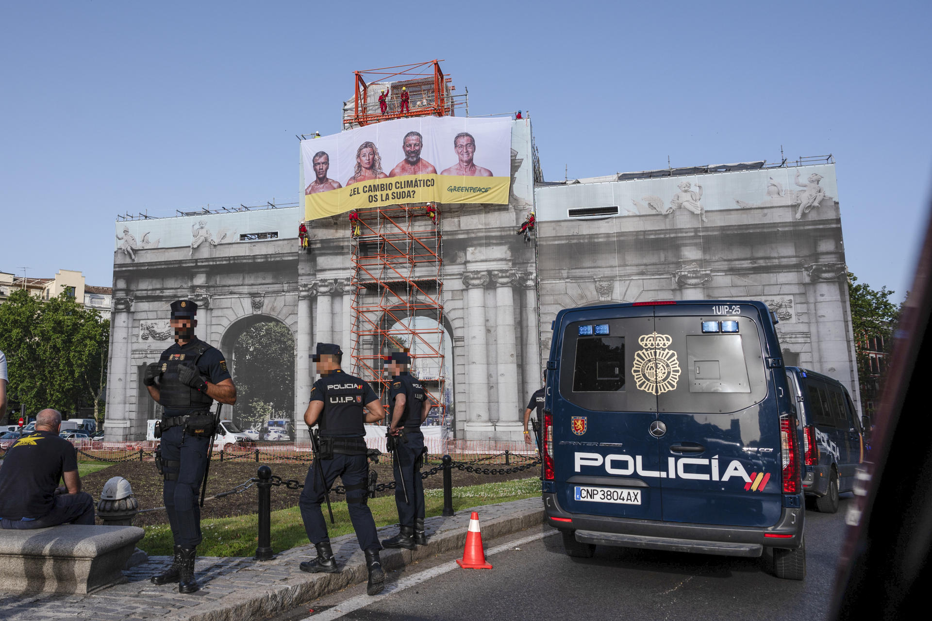 Activistas de Greenpeace han desplegado una lona en la emblemática Puerta de Alcalá de Madrid en la que preguntan a los principales candidatos a la presidencia del Gobierno, Pedro Sánchez (PSOE), Alberto Núñez Feijóo (PP), Santiago Abascal (Vox) y Yolanda Díaz (Sumar), si el cambio climático "se la suda". EFE/Fernando Villar
