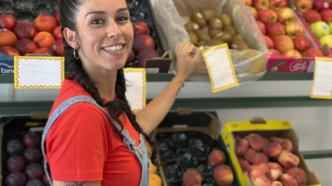 La joven Rocío Amador, en su frutería de Dos Hermanas (Sevilla), comercio que ha hecho viral mediante su iniciativa de cantar a la fruta y verdura o recitarle poesía, lo que ha hecho que en Instagram sigan cada día cientos de personas obras suyas como la Oda la berenjena o El Rap al higo. EFE/Fermín Cabanillas
