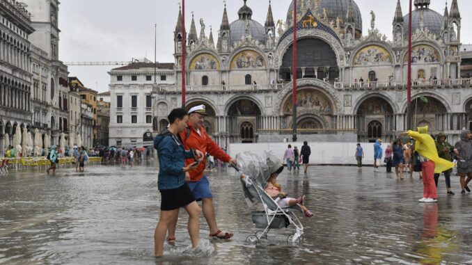 Varias personas caminan por una anegada plaza San Marcos de Venecia (Italia), este lunes 28 de agosto de 2023. Varias regiones del norte del país han sufrido fuertes tormentas estas últimas horas. EFE/ Andrea Merola
