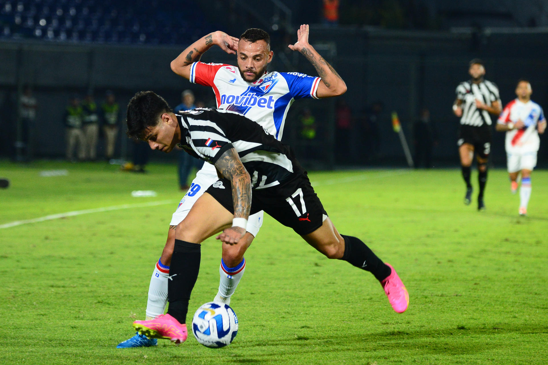 Matías Espinoza (i) de Libertad disputa el balón con Guilherme de Fortaleza en un partido de los octavos de final de la Copa Sudamericana entre Libertad y Fortaleza en el estadio Defensores del Chaco en Asunción (Paraguay). EFE/ Daniel Piris
