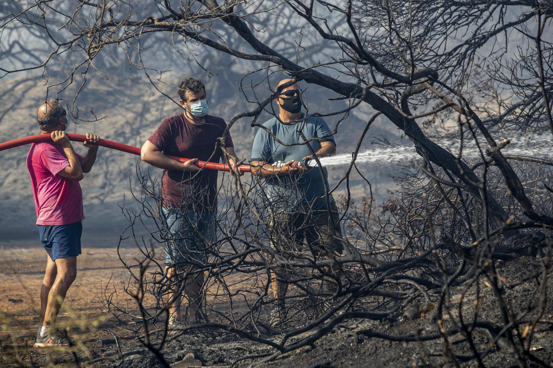 Vecinos y bomberos se afanan por apagar el incendio declarado esta tarde en el Paraje Natural de Las Canteras en Puerto Real (Cádiz).La AP-4, que une Cádiz con Sevilla, ha quedado cortada en ambos sentidos entre el kilómetro 104 y el 112 recomienda buscar vías alternativas, mientras que la circulación ferroviaria en este municipio está sufriendo retrasos. EFE/Román Ríos
