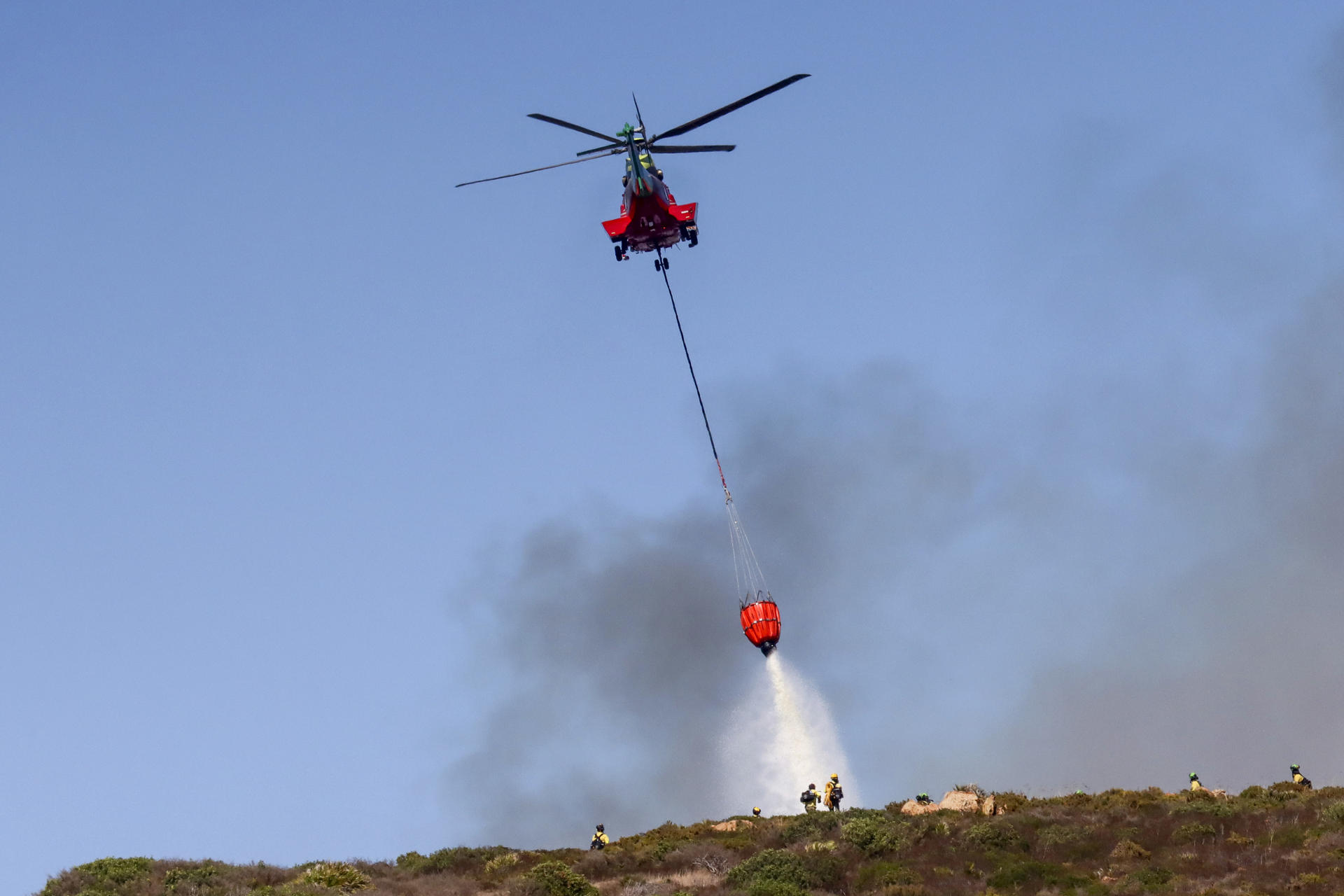 Labores de extinción de un incendio que ha sido declarado este martes en la zona de Santa Margarita en La Línea de la Concepción (Cádiz) y donde han participado varios helicópteros e hidroaviones. EFE/A.Carrasco Ragel.
