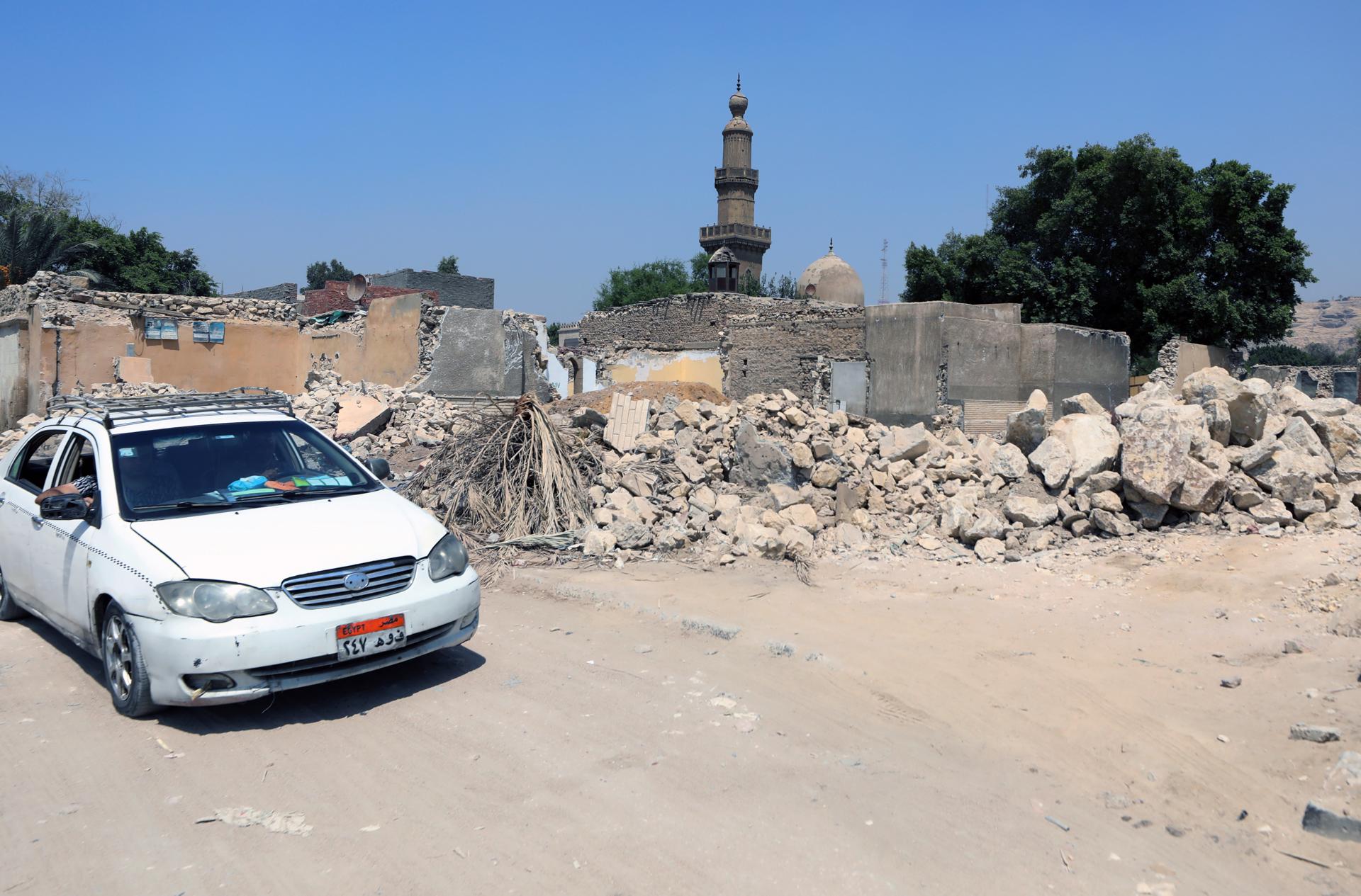 La Ciudad de los Muertos, la necrópolis medieval que forma parte de El Cairo histórico, está actualmente amenazada por el Gobierno de Egipto, que el pasado mes de mayo comenzó a demoler sus históricos mausoleos para dar paso a una nueva autopista, haciendo caso omiso a las advertencias de la Unesco y a su estatus como patrimonio de la Humanidad.
Las lápidas con inscripciones en árabe que sobresalen de entre las ruinas son el testigo de esta medida que busca unir el centro de El Cairo con la Nueva Capital Administrativa, una megalópolis en el desierto a unos 50 kilómetros al este de la ciudad, cuyo trazado atraviesa este camposanto con tumbas de más de 1.300 años donde yacen personajes ilustres de la historia, cultura y artes del país.
"Los cementerios se convirtieron en un museo que vinculaba este mundo y el más allá, y reunió los restos de aquellos que escribieron la historia de Egipto", publicó el investigador urbano egipcio Ibrahim Ezzeldin en la web The Tahrir Institute For Middle East Policy (TIMEP) a inicios de agosto. 
Este urbanista alertó de la pérdida que supone demoler este espacio donde descansan personalidades como Taqi al Din al Maqrizi, historiador cairota, cuya tumba ya fue demolida y retirada; mientras todavía resiste el sepulcro del escritor Taha Hussein, el "decano de las letras árabes", entre otros.
EFE/EPA/KHALED ELFIQI
