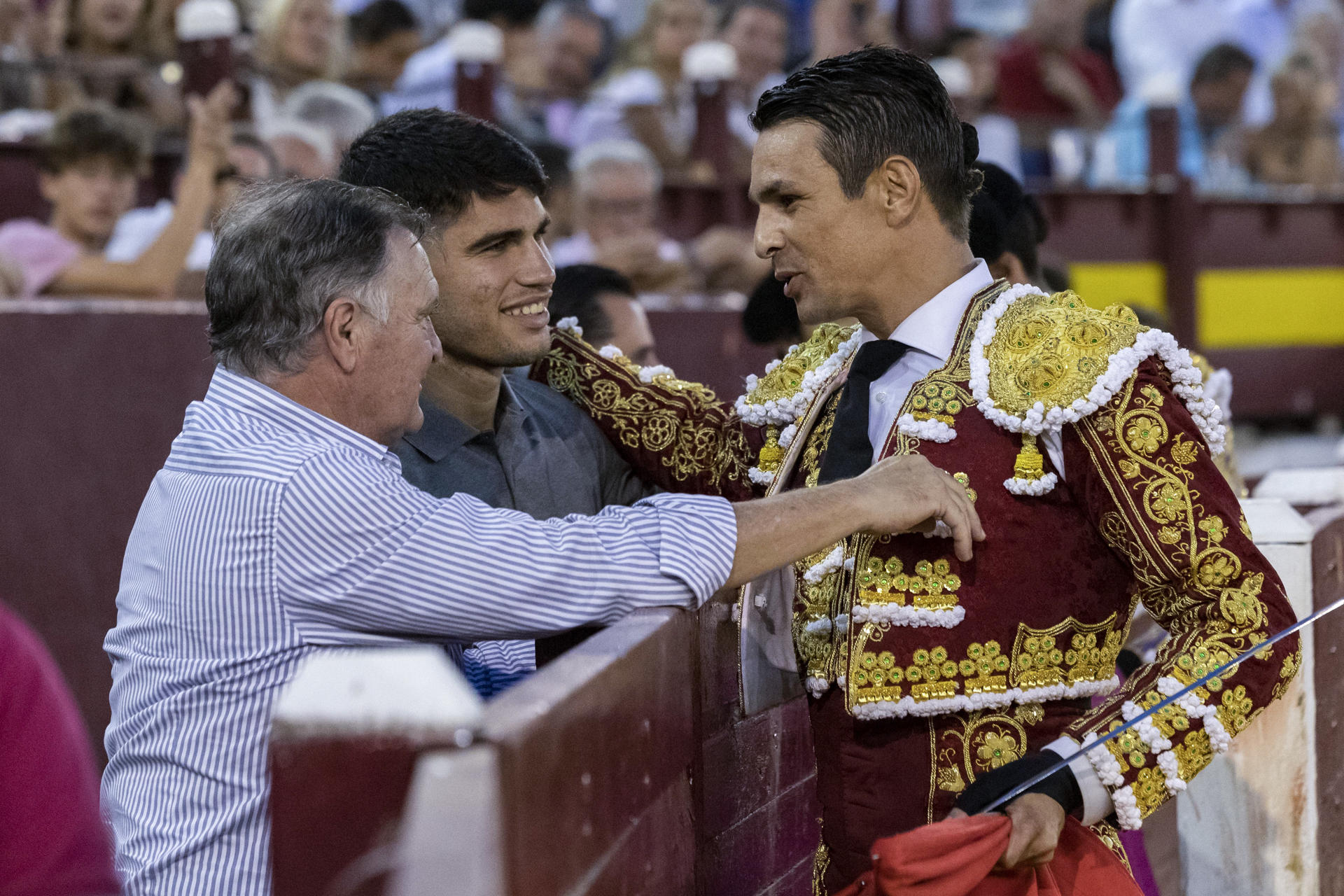 El torero alicantino José María Manzanares (d) brinda su segundo toro al tenista Carlos Alcaraz (c) y al ex seleccionador nacional de fútbol José Antonio Camacho (i) durante el segundo festejo de la Feria de Murcia celebrado hoy lunes en la plaza de La Condomina. EFE/Marcial Guillén
