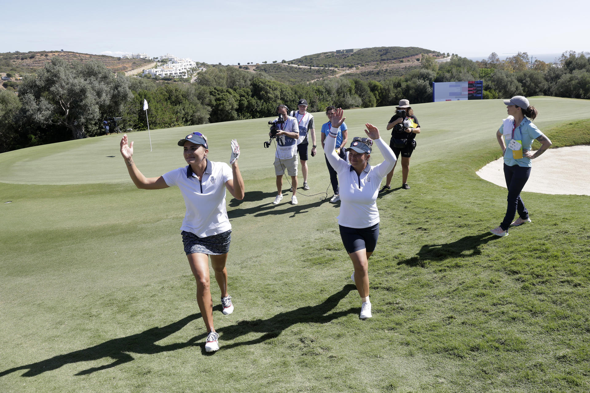 Las jugadoras americanas Lexi Thompson (izq) y Megan Khang saludan al público al terminar el hoyo 18, durante la segunda jornada del torneo SOLHEIM CUP de golf, donde se enfrentan los equipos europeo y americano, este sábado en el campo de golf de la Finca Cortesin en Casares (Málaga). EFE/A.Carrasco Ragel.
