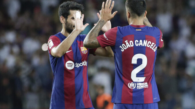 El defensa portugués del FC Barcelona Joao Cancelo (d) celebra con el centrocampista del FC Barcelona Ilkay Gündogan (i) al término del encuentro de la jornada 6 de LaLiga entre FC Barcelona y RC Celta de Vigo, este sábado en el Estadio Olímpico de Montjuic, en Barcelona. EFE/ Quique García
