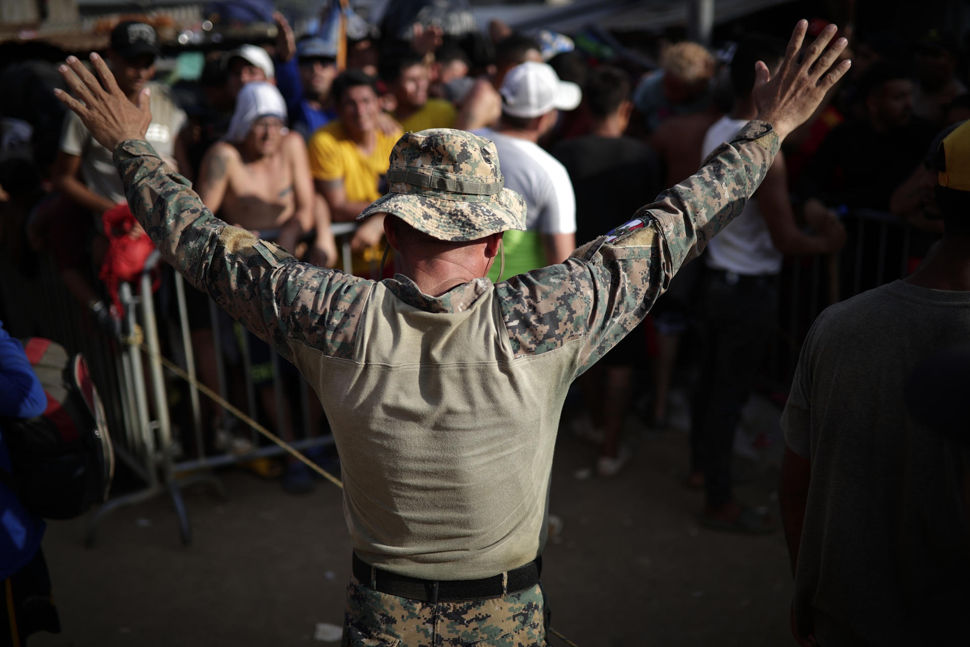 Un agente del Servicio Nacional de Fronteras (Senafront) de Panamá controla a migrantes que esperan en fila para hacer su registro ante agentes de migración, el 14 de septiembre de 2023 en el pueblo indígena de Bajo Chiquito (Panamá). EFE/ Bienvenido Velasco
