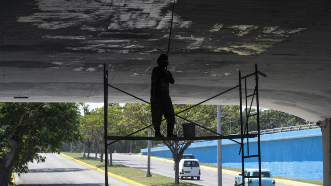 Un hombre pinta hoy un puente en la vía por la que pasarán las delegaciones de la Cumbre del G77 + China, en La Habana, (Cuba). EFE/Yander Zamora
