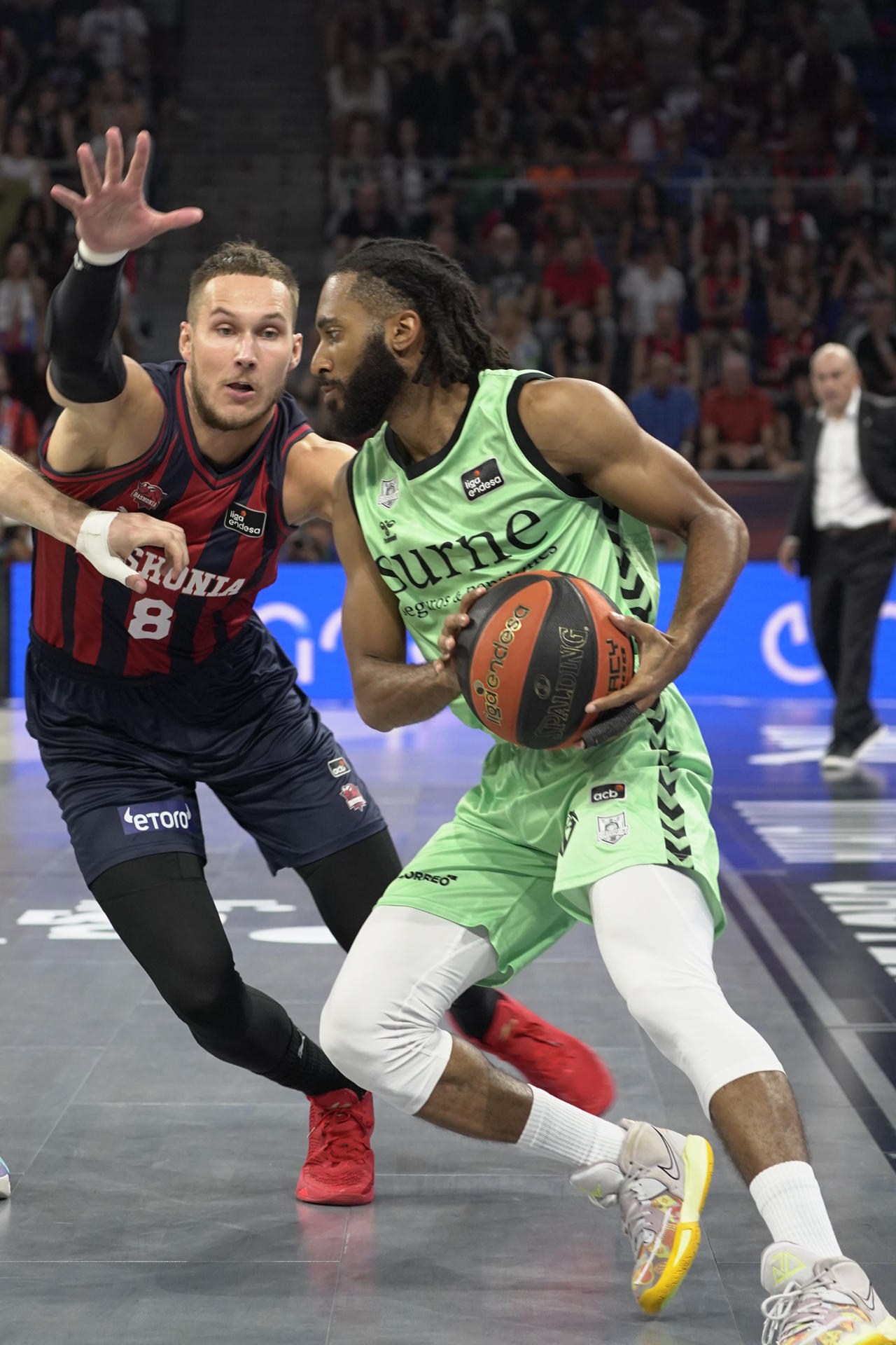 El alero estadounidense del Surne Bilbao Basket, Adam Smith (d) intenta superar al alero lituano del Baskonia, Tadas Sedekerskis , en el partido de la liga ACB de baloncesto disputado este sábado en el Fernando Buesa Arena de Vitoria-Gasteiz. EFE/ ADRIÁN RUIZ HIERRO
