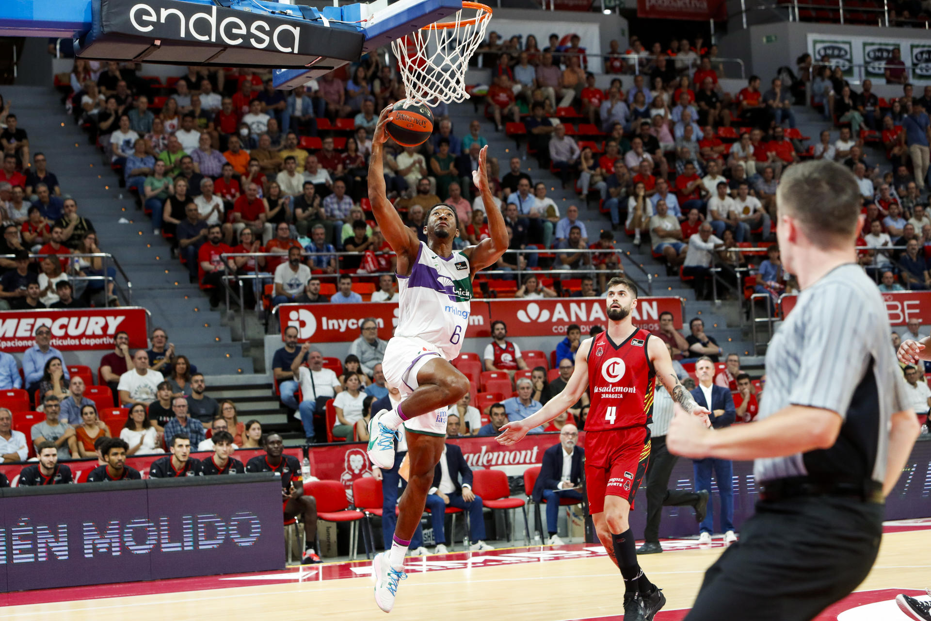 El jugador del Unicaja Kameron Taylor (i) entra a canasta ante Santiago Yusta (d), del Casademont Zaragoza, durante el partido de la Liga Endesa disputado esta tarde en Zaragoza. EFE/Javier Belver
