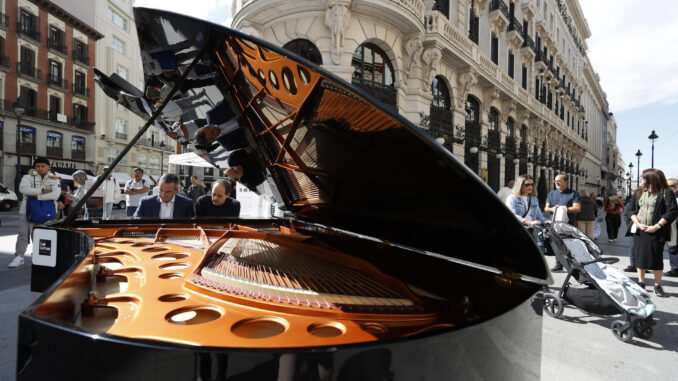 Una pianista toca un piano de cola en la Plaza de Sol en Madrid este viernes durante la iniciativa Pianos por Madrid. EFE/ Javier Lizón
