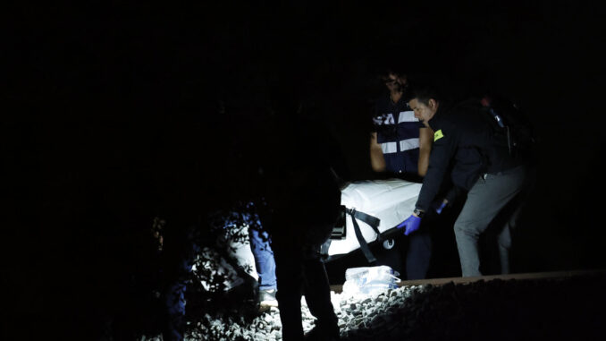 Los operarios retiran el último cadáver después de que cuatro personas fallecieran este domingo por la noche al ser arrolladas por un tren a la altura de Montmeló, en la comarca del Vallès Oriental (Barcelona), cuando un grupo de siete personas trataba de cruzar la vía por un punto no autorizado. EFE/Alberto Estévez
