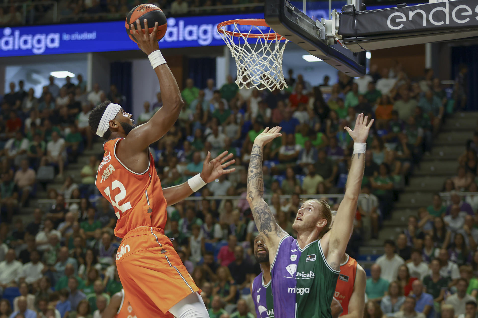 El pívot estadounidense del Valencia Basket Brandon Davies (i) lanza a canasta ante el ala pívot estadounidense del Unicaja Dylan Osetkowski durante la tercera jornada de la liga ACB que enfrentó al Unicaja Málaga y al Valencia Basket en el Palacio de los Deportes José María Martín Carpena de Málaga. EFE/Álvaro Cabrera
