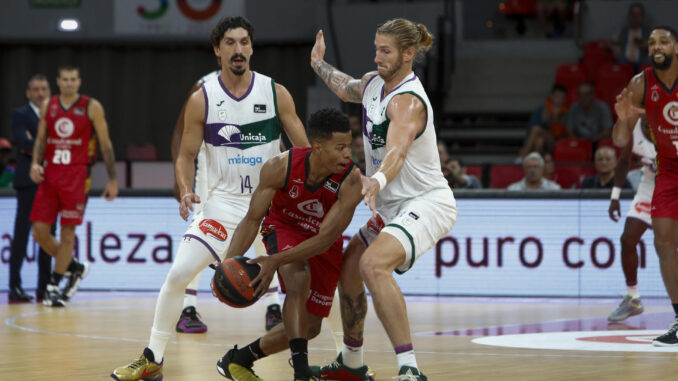 El base del Casademont Zaragoza Trae Bell-Haynes (c) controla la pelota ante los jugadores del Unicaja Djedovic (i) y Osetkowski (d), durante el partido de la Liga Endesa disputado esta tarde en Zaragoza. EFE/Javier Belver
