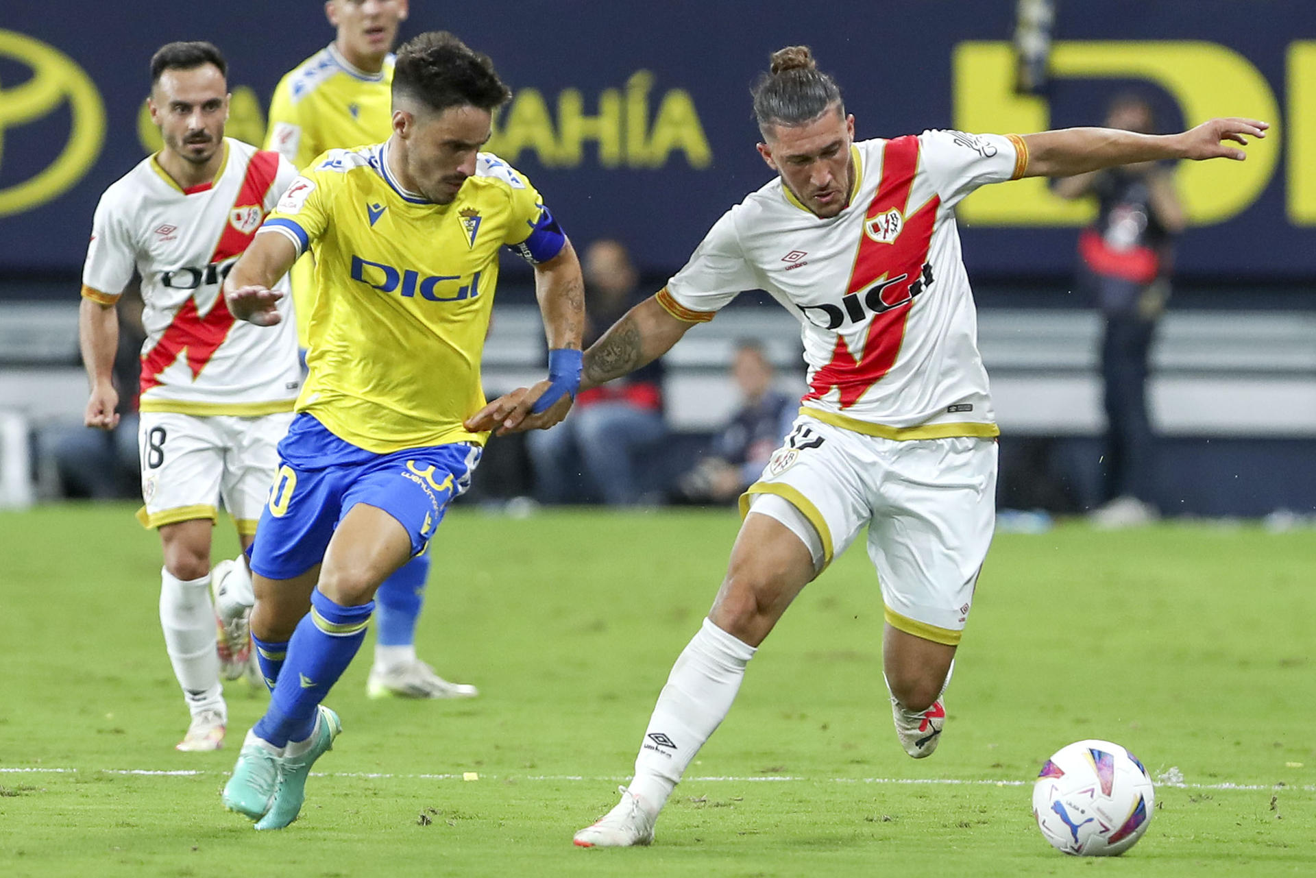 El defensa del Rayo Vallecano Pacha Espino (d) lucha por el balón con el defensa del Cádiz CF Iza (i) durante el partido de LaLiga que enfrenta al Cádiz CF y al Rayo Vallecano este miércoles en el estadio Nuevo Mirandilla. EFE/Román Ríos
