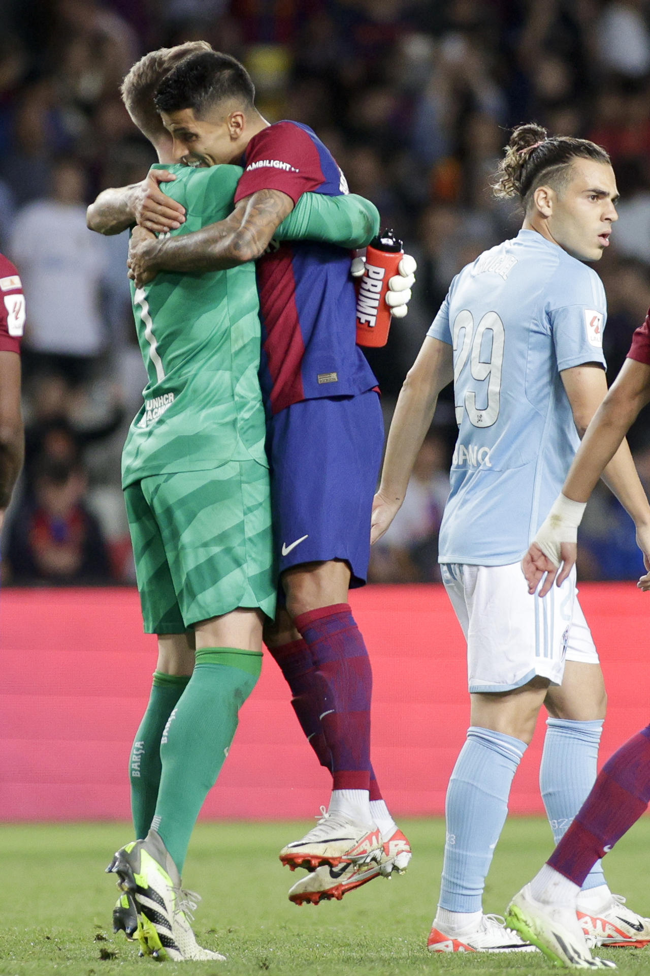 El defensa portugués del FC Barcelona Joao Cancelo (d) celebra con el portero del FC Barcelona Marc-André Ter Stegen (i) al término del encuentro de la jornada 6 de LaLiga entre FC Barcelona y RC Celta de Vigo, este sábado en el Estadio Olímpico de Montjuic, en Barcelona. EFE/ Quique García
