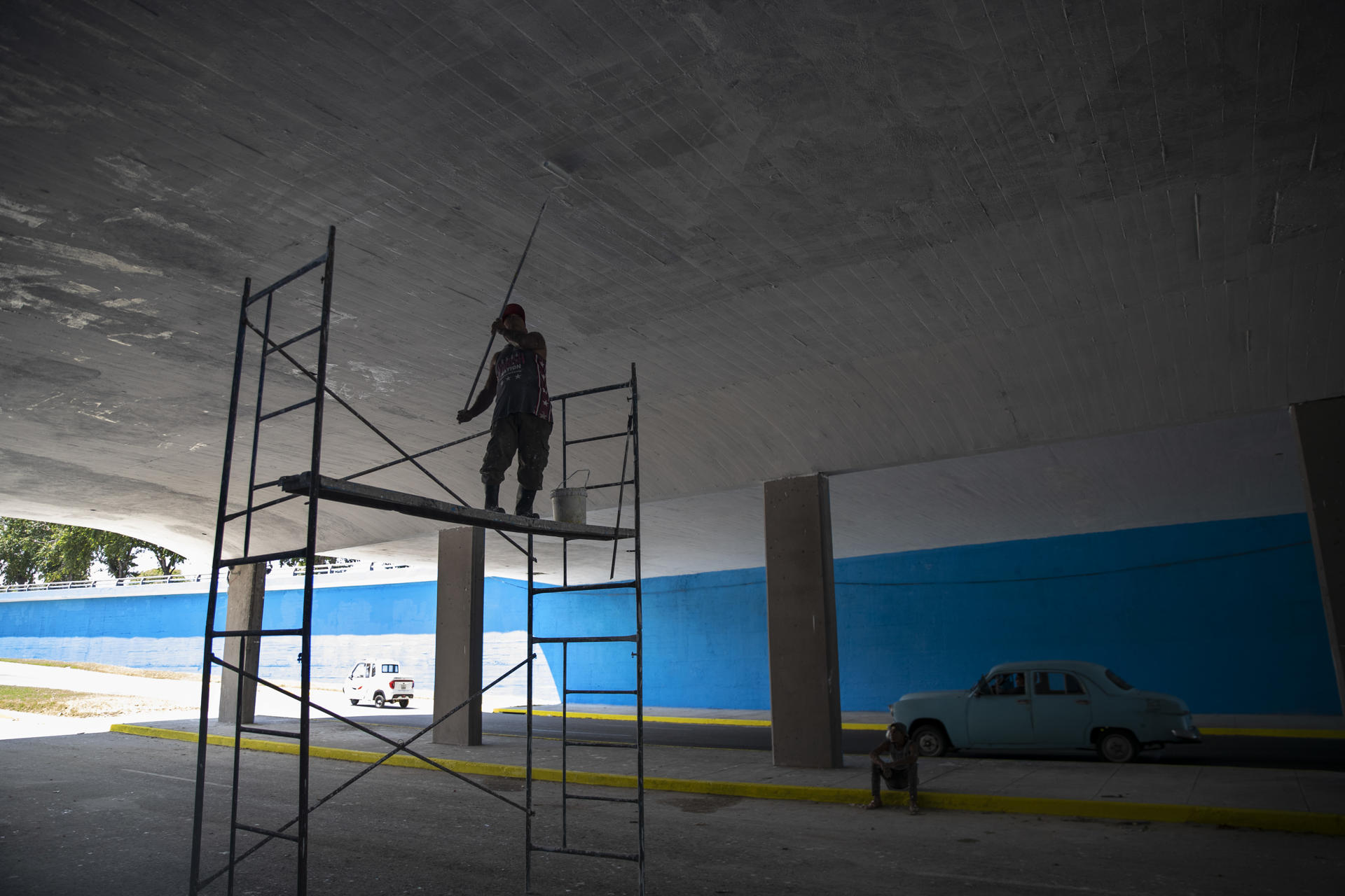 Un hombre pinta hoy un puente en la vía por la que pasarán las delegaciones de la Cumbre del G77 + China, en La Habana (Cuba). EFE/Yander Zamora
