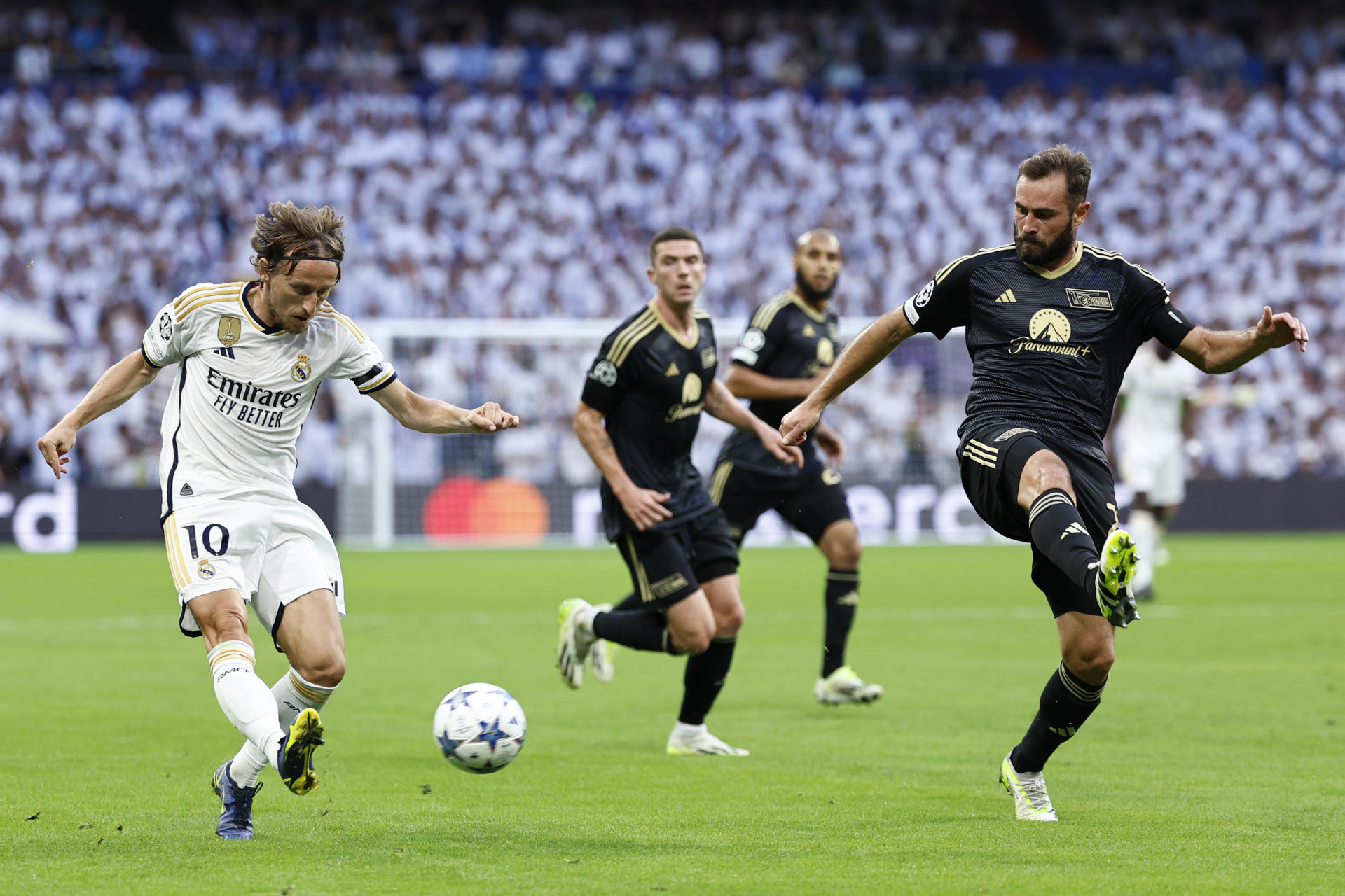 El centrocampista croata del Real Madrid Luka Modric (i) trata de centrar ante la oposición de Lucas Tousart (d), centrocampista francés del Unión Berlín, durante el encuentro del grupo C de Liga de Campeones entre Real Madrid y Unión Berlín, en el Estadio Santiago Bernabéu en Madrid. EFE/ Rodrigo Jiménez
