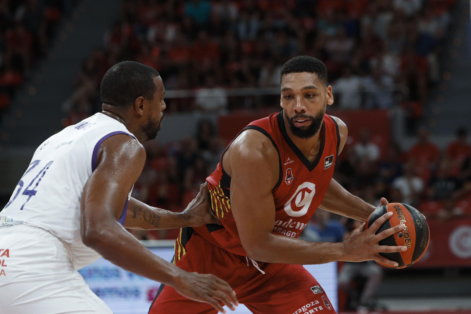 El jugador del Casademont Zaragoza Jahlil Okafor (d) controla la pelota ante Will Thomas, del Unicaja Djedovic (i), durante el partido de la Liga Endesa disputado esta tarde en Zaragoza. EFE/Javier Belver
