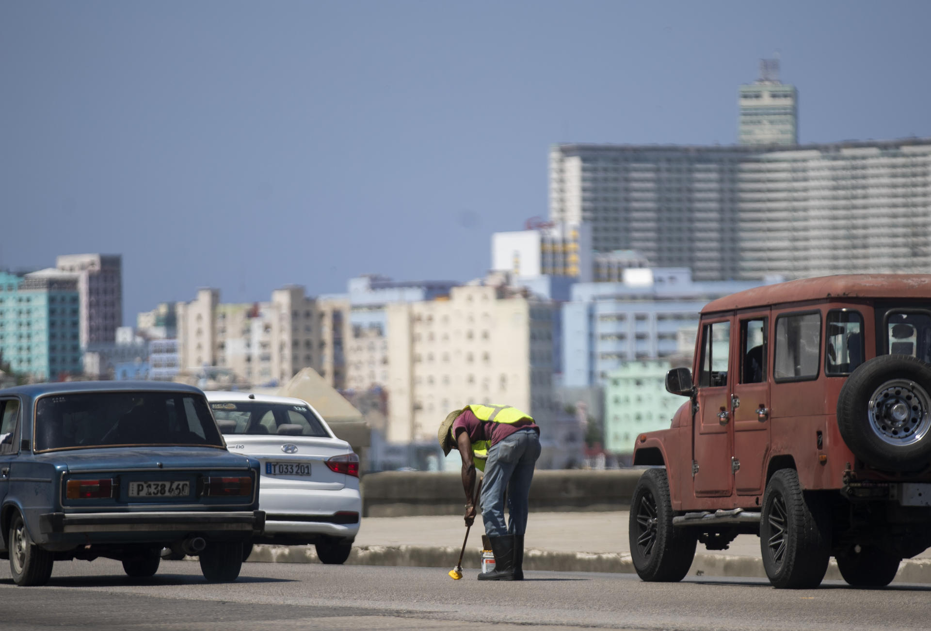 Un hombre pinta hoy señales de tránsito en el Malecón, vía por la que pasarán las delegaciones de la Cumbre del G77 + China, en La Habana (Cuba). EFE/Yander Zamora
