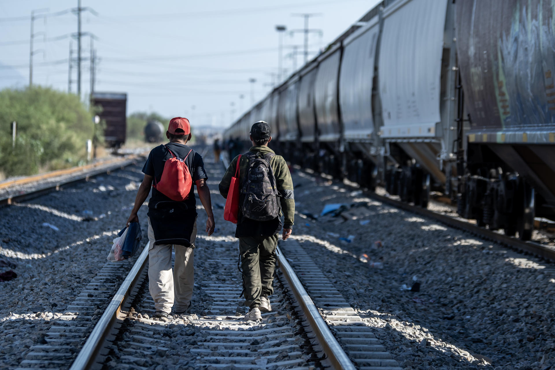 Migrantes caminan por las vías del tren en su intención de llegar a la frontera con Estados Unidos en el municipio de Escobedo (México). EFE/Miguel Sierra
