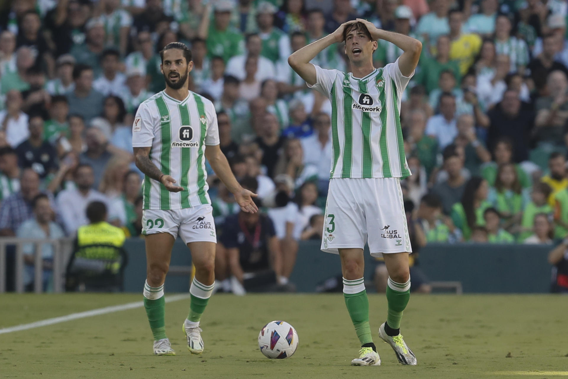 El defensa del Betis Miranda (d) junto a su compañero Isco reacciona este domingo, durante el partido de liga disputado en el estadio Benito Villamarín de Sevilla. EFE/ José Manuel Vidal
