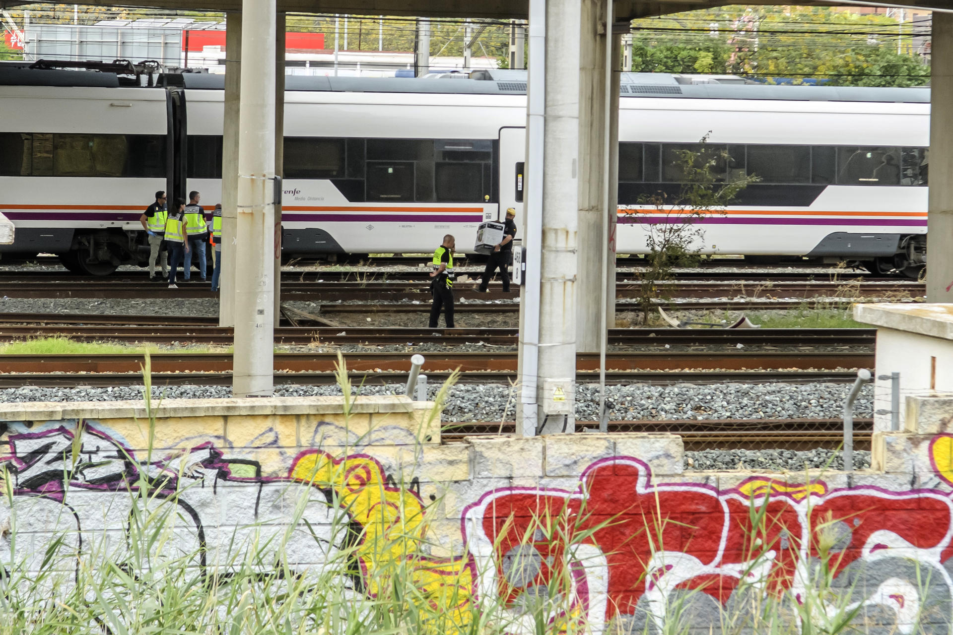 Agentes del Cuerpo Nacional de Policía y de seguridad de Renfe junto al cuerpo de una persona que ha sido hallado este lunes entre dos vagones de un tren en la estación de Santa Justa de Sevilla, donde el pasado jueves desapareció el joven cordobés de 18 años Álvaro Prieto. EFE/ Raúl Caro
