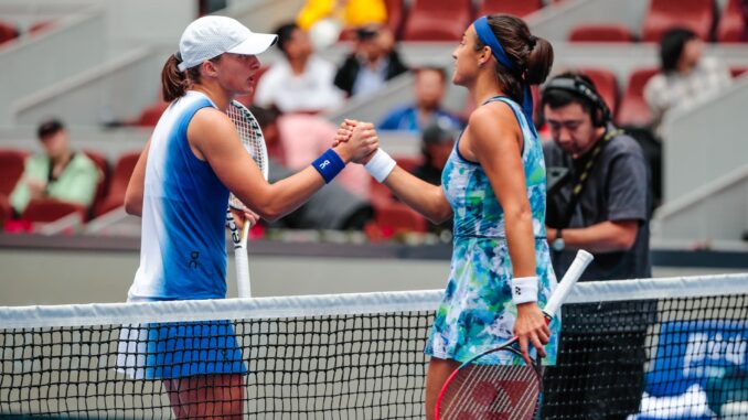 Iga Swiatek de Polonia (L) le da la mano a Caroline García de Francia después de su partido de cuartos de final en el torneo de tenis Abierto de China en Beijing, China. EFE/EPA/WU HAO
