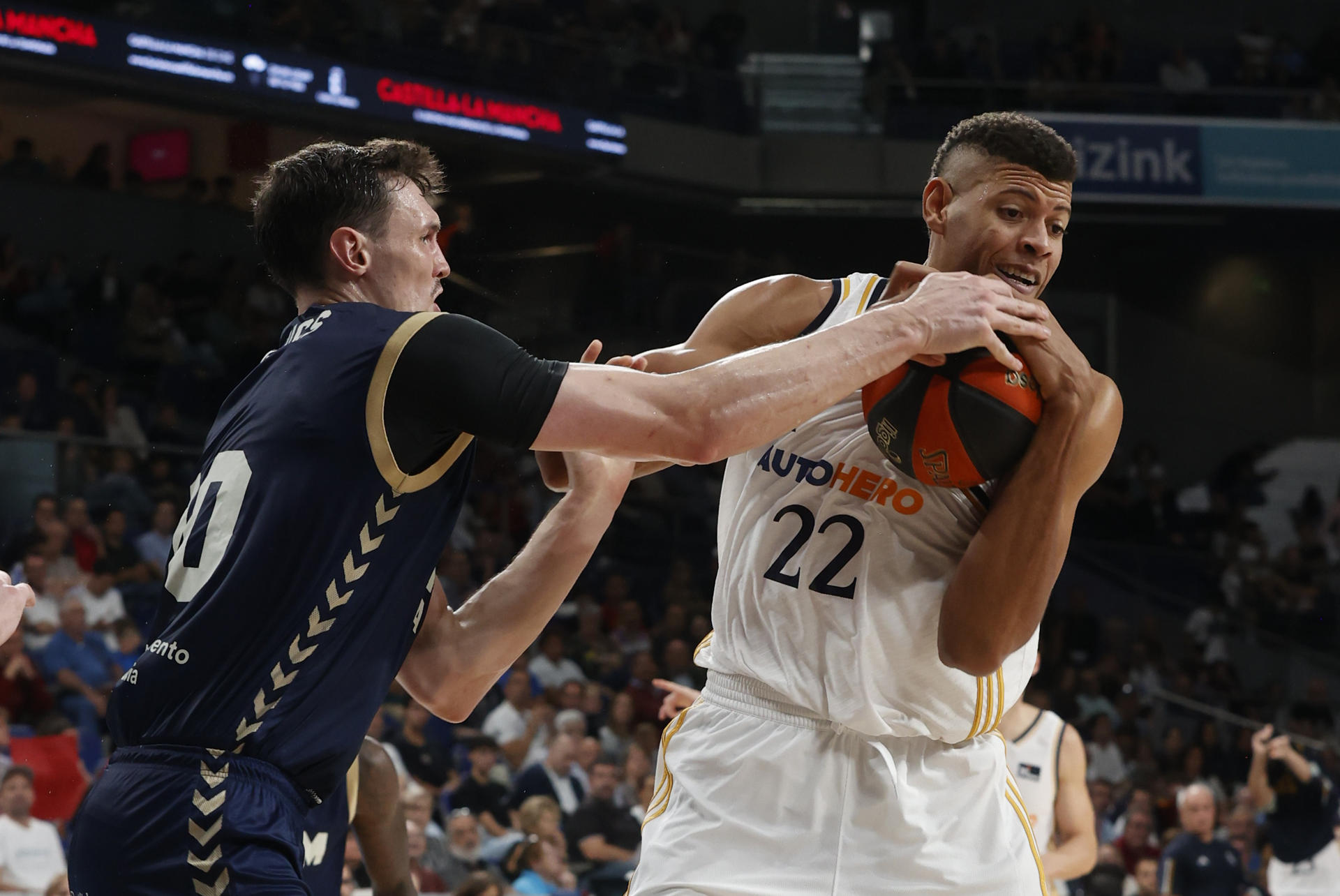 El pívot caboverdiano del Real Madrid (d) Walter Tavares disputa una posesión ante Troy Caupain (i) escolta estadounidense del UCAM Murcia durante el partido de la jornada 5 de la Liga Endesa entre Real Madrid y UCAM Murcia en el WiZink Center de Madrid. EFE/ Juan Carlos Hidalgo
