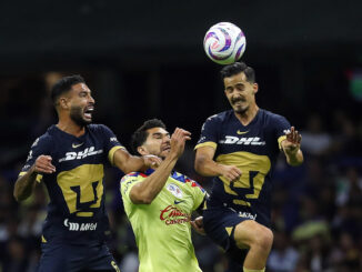 Henry Martín (c) del América (i) disputa un balón con Nathanael Ananias (i) y Pablo Bennevendo (d) de Pumas, hoy durante un juego por la jornada 10 del torneo Apertura 2023 de la Liga MX del fútbol mexicano en el estadio Azteca en Ciudad de México (México). EFE/Sáshenka Gutiérrez