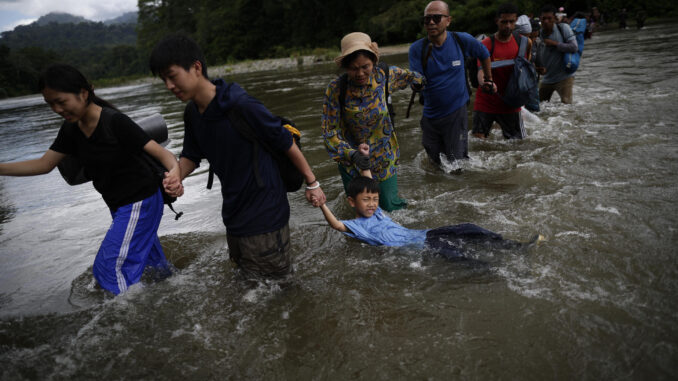 Migrantes cruzan el río Turquesa, en Darién (Panamá). EFE/Bienvenido Velasco
