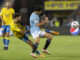 El centrocampista de Las Palmas Munir El Haddadi (c) pelea un balón con el defensa del Celta Manu Sánchez (d) durante el partido de LaLiga que se disputó en el estadio de Gran Canaria. EFE/ Quique Curbelo