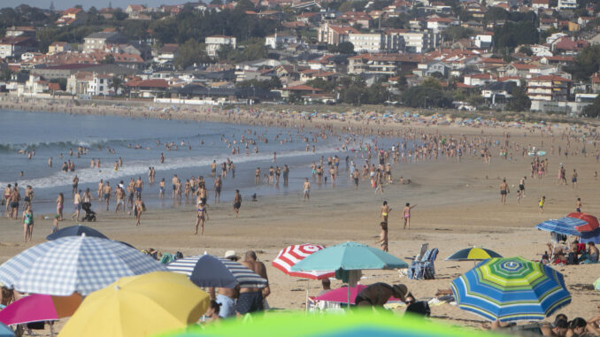 Cientos de personas se han acercado este sábado a la playa América de Nigrán, en Galicia, para disfrutar de las altas temperaturas registradas en la región. EFE / Salvador Sas
