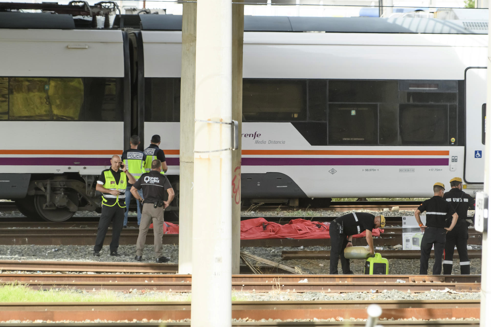 Agentes del Cuerpo Nacional de Policía, de la UME y de seguridad de Renfe junto al cuerpo de una persona que ha sido hallado este lunes entre dos vagones de un tren en la estación de Santa Justa de Sevilla, donde el pasado jueves desapareció el joven cordobés de 18 años Álvaro Prieto. EFE/ Raúl Caro
