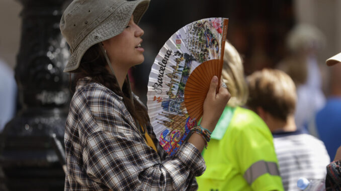 Una turista intenta refrescarse con un abanico en el centro de Barcelona, en una fotografía de archivo. EFE/Quique García
