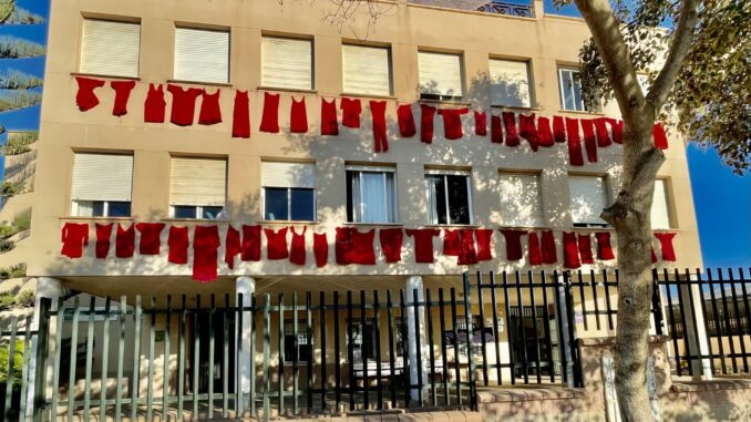 Imagen facilitada por el IES Alfaguar de Torrox (Málaga) y realizada por Eloy Melero de la fachada del centro, en la que con prendas de vestir de color rojo representan a las víctimas de violencia machista, que son recordadas en un cortometraje en el que participan sus alumnas, dentro de una campaña con motivo del Día Internacional de la Eliminación de la Violencia contra las Mujeres. EFE IES Alfaguar de Torrox.SOLO USO EDITORIAL/SOLO DISPONIBLE PARA ILUSTRAR LA NOTICIA QUE ACOMPAÑA (CRÉDITO OBLIGATORIO)
