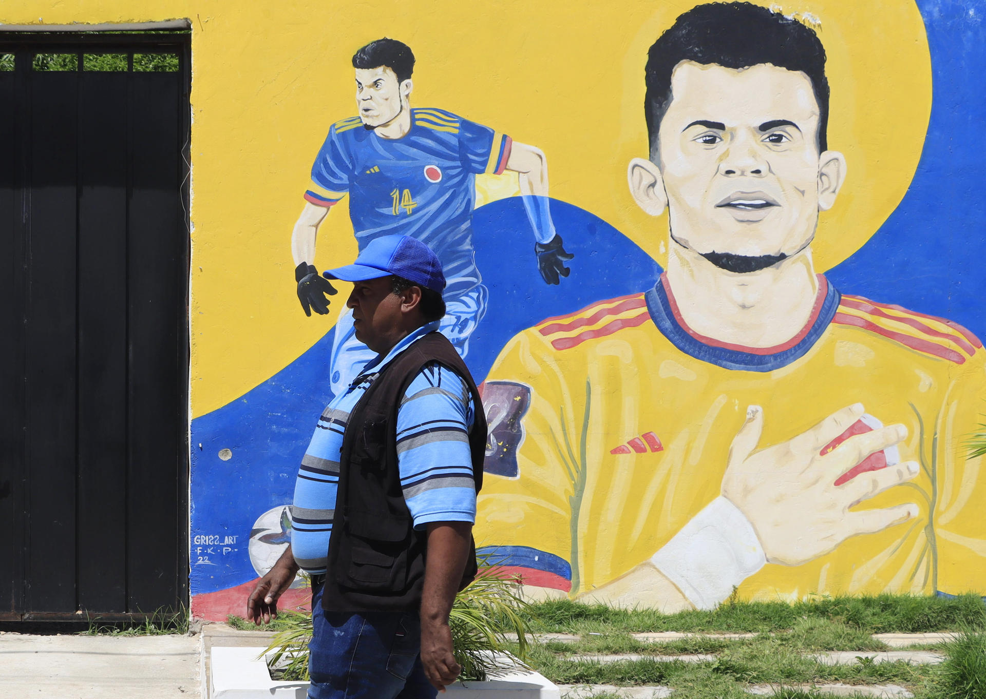 Una persona camina frente a un mural en la casa familiar del futbolista colombiano Luis Díaz, hoy, en Barrancas, departamento de La Guajira (Colombia). EFE/Ricardo Maldonado Rozo
